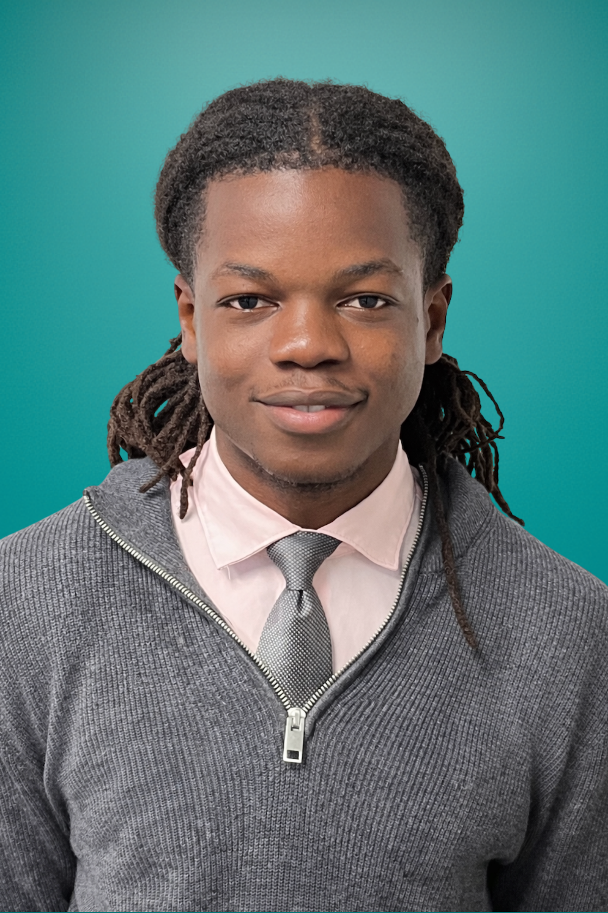 Empowered young man with dreadlocks in professional attire against teal background.